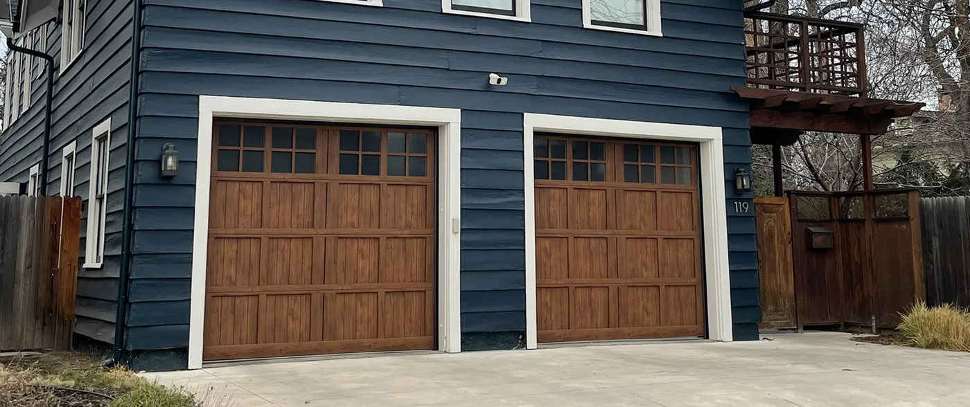 blue house with double car garage with wood doors